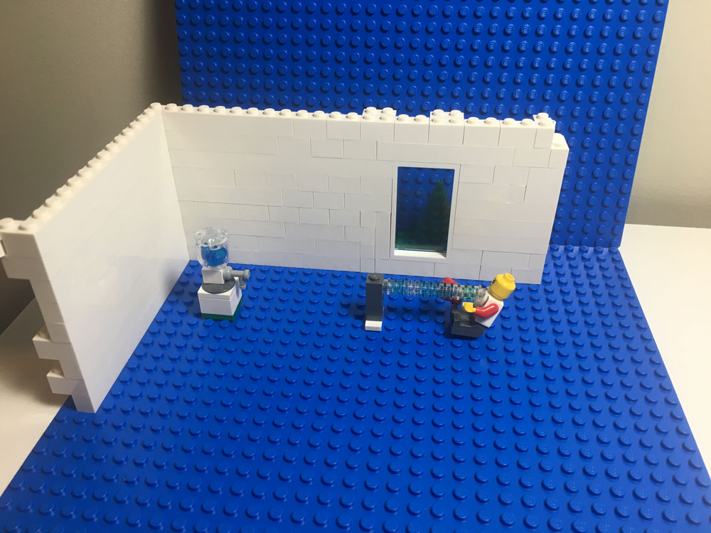 Behind the scenes shot of 'the water cooler' showing the minifig getting blasted with water.